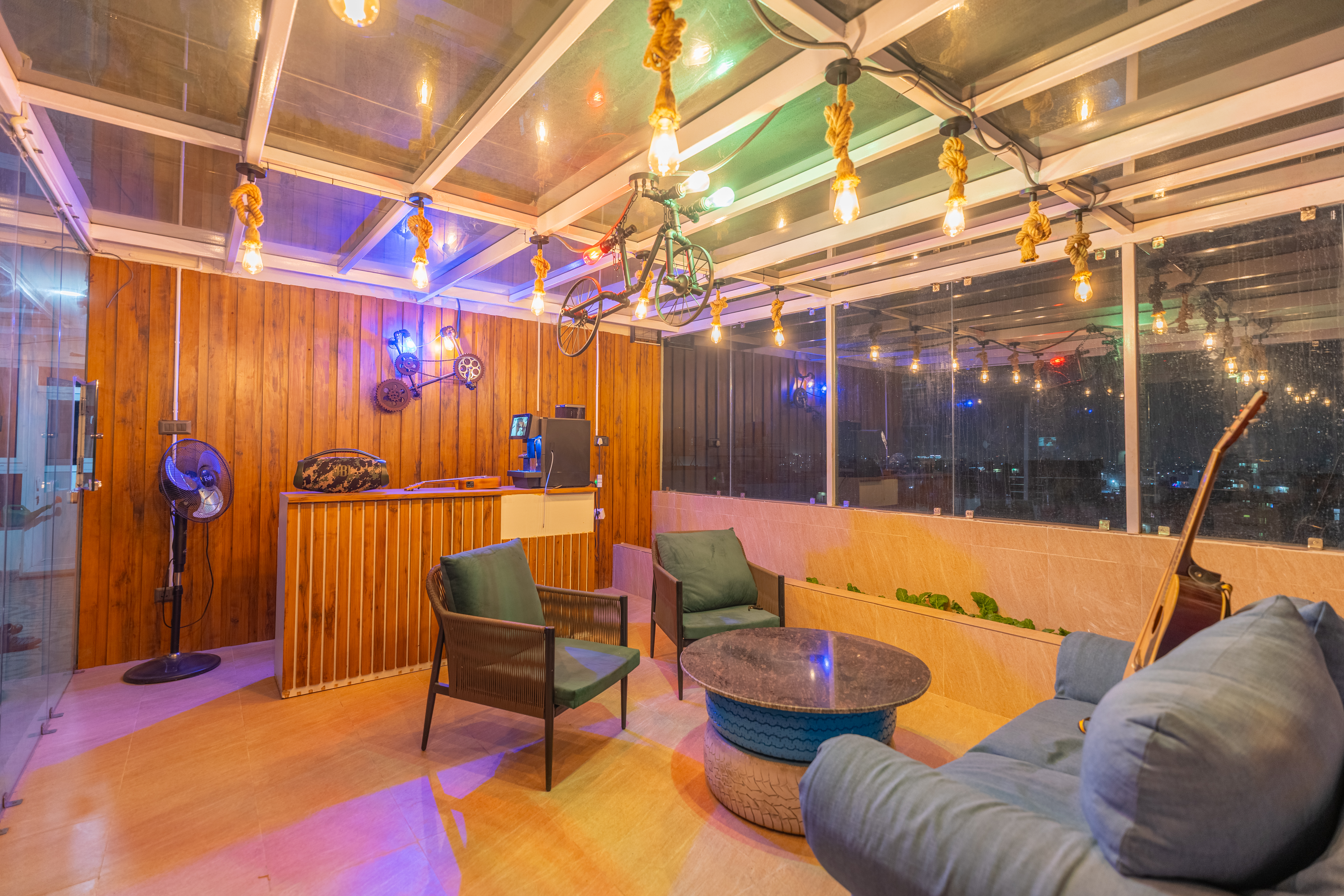 Glass rooftop lounge with Edison lighting and city views